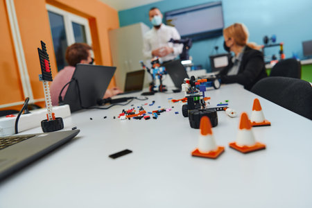 A group of colleagues working together in a robotics laboratory, focusing on the intricate fields of...