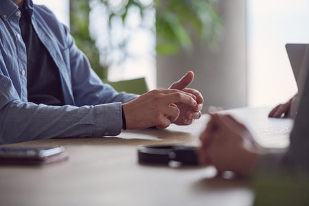 Closeup photo, the hands of businessmen sitting at a business meeting can be seen as they discuss...