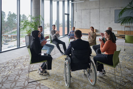 In a modern office, a diverse group of business individuals is seen gathered in a circle, engaged in...