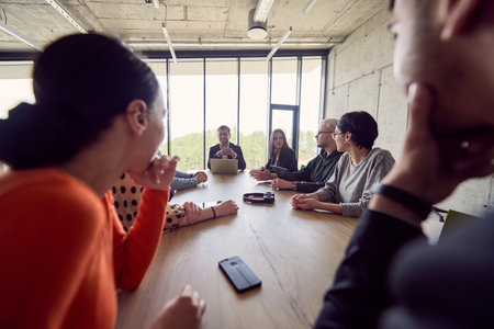 A diverse group of business professionals gathered at a modern office for a productive and inclusive meetingの写真素材