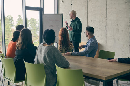 In a modern office setting, a group of business professionals attentively listens to a captivating...