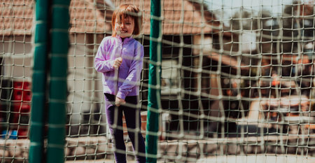 A little girl playing in the park. The concept of family socializing in the park. A girl swings on a swing, plays creative gamesの写真素材