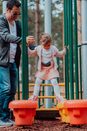 Family time in the park. Father have fun with his daughter in the park, playing fun games and spending time togetherの写真素材