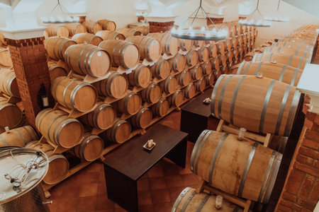Wine or cognac barrels in the cellar of the winery, Wooden wine barrels in perspective. Wine...