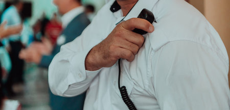 A close-up photo of a guard holding a communication device