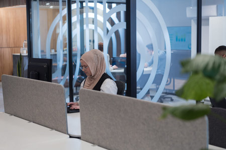In a modern office setting, an African American businessman and his Muslim colleague, wearing a...