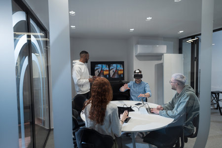 A diverse group of businessmen collaborates and tests a new virtual reality technology, wearing virtual glasses, showcasing innovation and creativity in their futuristic workspaceの写真素材