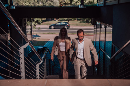 Modern business couple after a long days work, walking together towards the comfort of their home,...