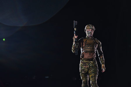 A professional soldier in full military gear striding through the dark night as he embarks on a...