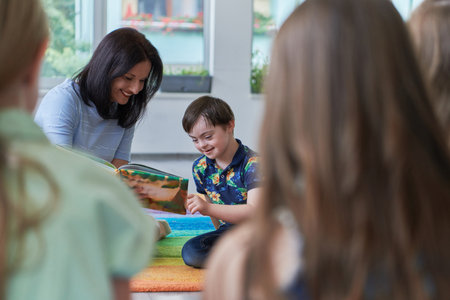 Reading time in an elementary school or kindergarten, a teacher reading a book to children in an elementary school or kindergarten. The concept of pre-school education. Selective focusの写真素材