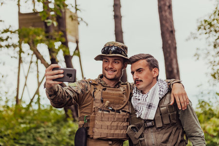 Team of soldiers and terrorist taking selfie with smartphone in the forestの写真素材