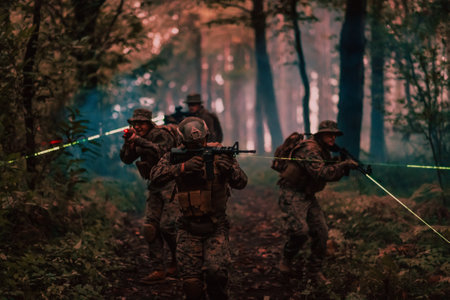 Soldiers squad in action on night mission using laser sight beam lights military team conceptの写真素材