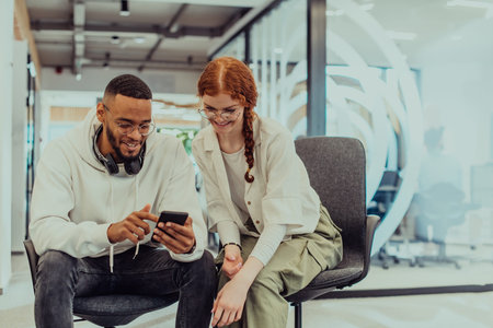 In a modern office African American young businessman and his businesswoman colleague, with her...