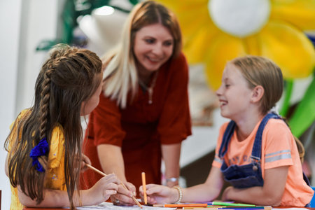 Creative kids during an art class in a daycare center or elementary school classroom drawing with...
