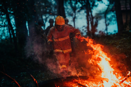 firefighter hero in action danger jumping over fire flame to rescue and saveの写真素材