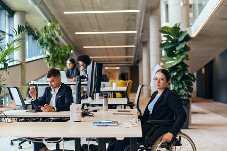 In a modern startup office, a diverse group of young professionals collaboratively tackles various business problems and challenges, surrounded by their engaged colleagues, fostering innovation and productivityの写真素材