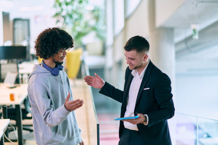 In a modern office setting, an African American businessman and his director confidently extend their hands in congratulations, symbolizing successful resolution of a business problem, amidst a backdrop of professionalism and collaboration.の写真素材