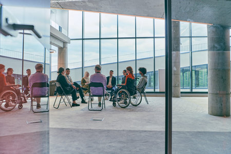 A diverse group of young business entrepreneurs gathered in a circle for a meeting, discussing...