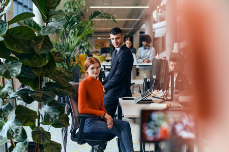 In a modern startup office, a diverse group of young professionals collaboratively tackles various business problems and challenges, surrounded by their engaged colleagues, fostering innovation and productivityの写真素材