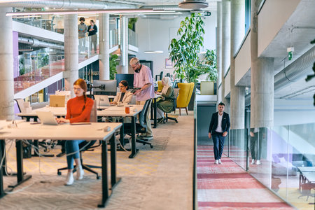 In a modern startup office, a diverse group of young professionals collaboratively tackles various business problems and challenges, surrounded by their engaged colleagues, fostering innovation and productivityの写真素材