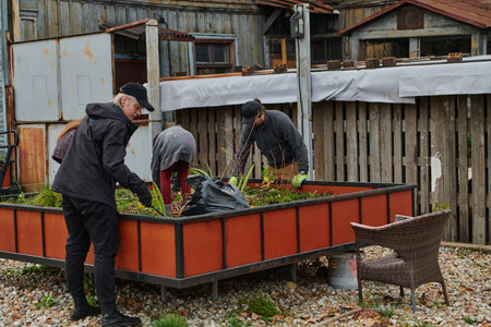 A modern family parents and children, is working together to beautify their front yard with flowers...