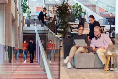 In a modern startup office, a diverse group of young professionals collaboratively tackles various business problems and challenges, surrounded by their engaged colleagues, fostering innovation and productivityの写真素材