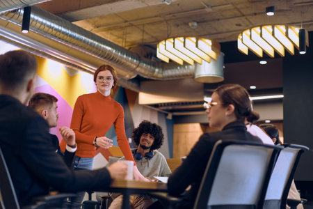 A diverse team of business experts in a modern glass office, attentively listening to a colleagues...