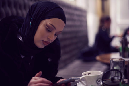 Muslim woman walking on an urban city street on a cold winter night wearing hijabの写真素材