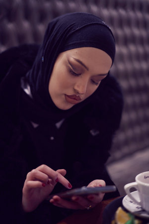 Muslim woman walking on an urban city street on a cold winter night wearing hijabの写真素材