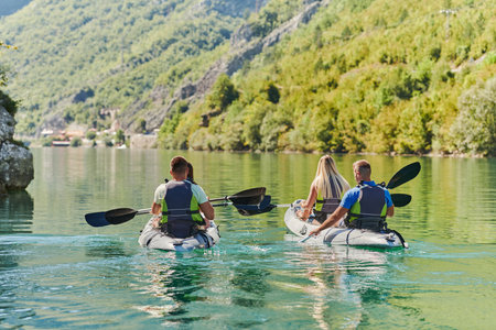 A group of friends enjoying having fun and kayaking while exploring the calm river, surrounding forest and large natural river canyonsの写真素材