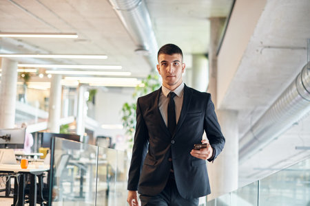 In a sleek corporate setting, the young and charismatic director strides confidently down the hallway, symbolizing his dynamic leadership and the promise of continued success within the company he guidesの写真素材