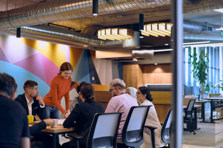 A diverse team of business experts in a modern glass office, attentively listening to a colleagues...