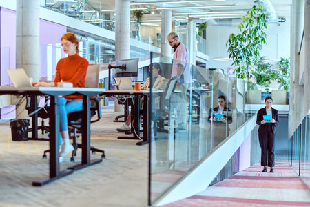 In a modern startup office, a diverse group of young professionals collaboratively tackles various business problems and challenges, surrounded by their engaged colleagues, fostering innovation and productivityの写真素材