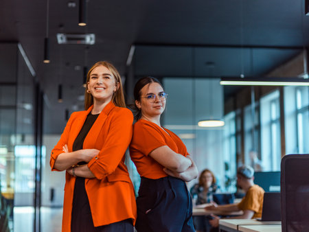 Group of determined businesswomen confidently pose side by side in a modern startup coworking center, embodying professionalism and empowermentの写真素材