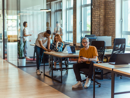 A diverse group of young business individuals congregates in a modern startup coworking center, embodying collaborative innovation and a dynamic atmosphereの写真素材