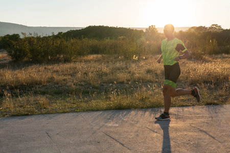 Triathlete in professional gear running early in the morning, preparing for a marathon, dedication...