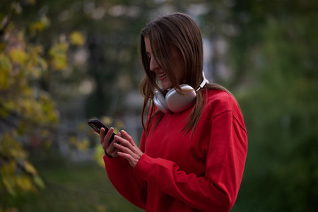 Sporty woman checks smartphone before doing some exercises listens music from a playlistの写真素材