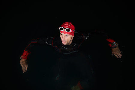 A triathlete finds serene rejuvenation in a lake, basking in the tranquility of the water after an...