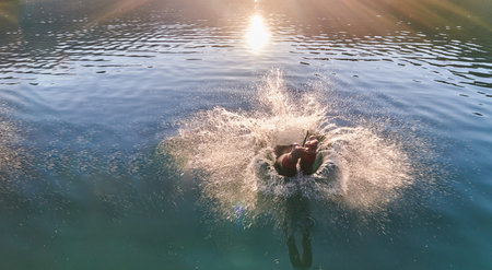 Triathlon athlete swimming on lake in sunrise wearing wetsuit