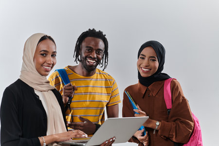 A group of students, including an African American student and two hijab-wearing women, stand united against a pristine white background, symbolizing a harmonious blend of cultures and backgrounds in the pursuit of knowledge and academic excellenceの写真素材