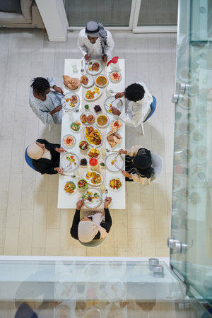 Top view of traditional and diverse Muslim family comes together to share a delicious iftar meal during the sacred month of Ramadan, embodying the essence of familial joy, cultural richness, and spiritual unity in their shared celebrationの写真素材