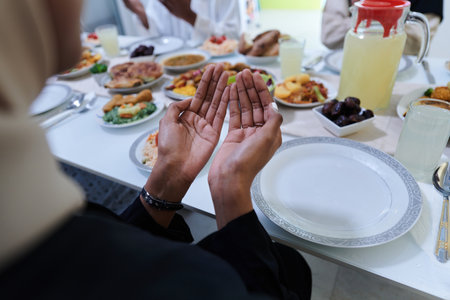 In the sacred month of Ramadan, a diverse Muslim family comes together in spiritual unity, fervently praying to God before breaking their fast, capturing a moment of collective devotion, cultural diversity, and familial joy in the midst of the holy celebrationの写真素材