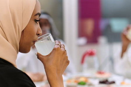 A traditional and diverse Muslim family comes together to share a delicious iftar meal during the sacred month of Ramadan, embodying the essence of familial joy, cultural richness, and spiritual unity in their shared celebrationの写真素材