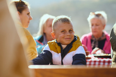 A family on a mountain vacation indulges in the pleasures of a healthy life, savoring traditional...