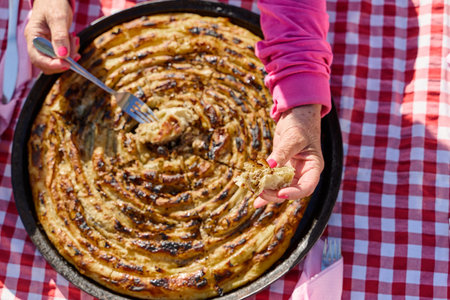 Exquisitely prepared, this traditional Bosnian dish showcases a mouthwatering pie under its lid,...