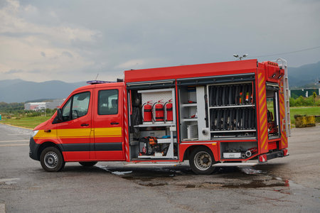 A state-of-the-art firetruck, equipped with advanced rescue technology, stands ready with its skilled firefighting team, prepared to intervene and respond rapidly to emergencies, ensuring the safety and protection of the community. High quality photoの写真素材