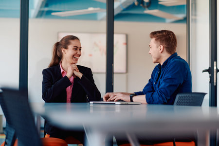 A business leader in a suit conversing with her worker in the IT industry about new business...