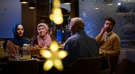 A modern and traditional European Islamic family comes together for iftar in a contemporary restaurant during the Ramadan fasting period, embodying cultural harmony and familial unity amidst a culinary celebration of diversityの写真素材