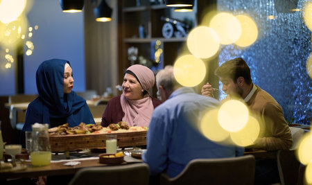 A modern and traditional European Islamic family comes together for iftar in a contemporary restaurant during the Ramadan fasting period, embodying cultural harmony and familial unity amidst a culinary celebration of diversityの写真素材