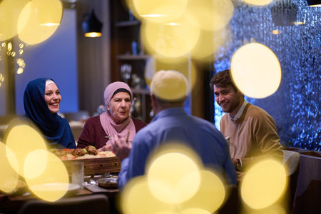 A modern and traditional European Islamic family comes together for iftar in a contemporary restaurant during the Ramadan fasting period, embodying cultural harmony and familial unity amidst a culinary celebration of diversityの写真素材